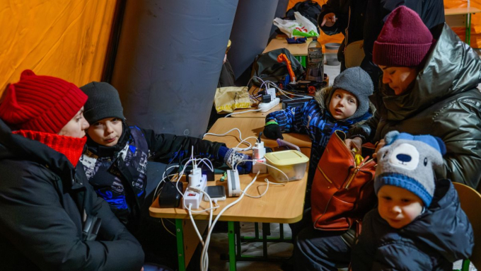 Mieszkańcy Kijowa gromadzą się w ogrzewanym namiocie. Prawie 60 procent miasta jest bez prądu po wtorkowych rosyjskich atakach na obiekty energetyczne; fot. PAP/Vladyslav Musiienko 